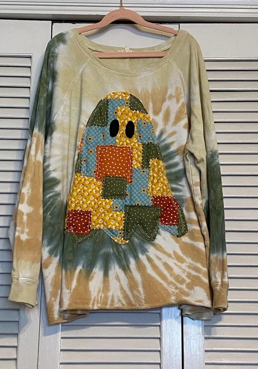 Tie-dye sweatshirt with a ghost design made of colorful, patterned fabric patches.